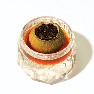 Preserved orange tea in a clear container on a white background