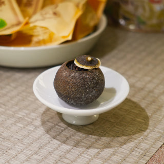 A close-up of an unwrapped Tea Mama Xiaoqinggan, showing the desirable white citrus frost (bai shuang) on its lid, a sign of its quality and age.
